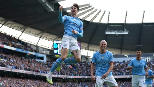 John Stones pictured jumping into the air to celebrate after scoring for Manchester City against Leicester in April 2023